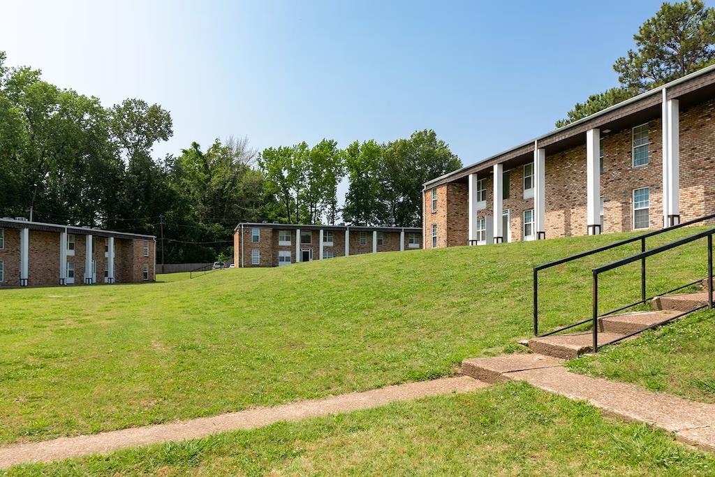 3236 Millington Road Memphis, TN 38127 - Photo 5 of 31 Brick exterior buildings with white columns, set on a sloped grassy terrain