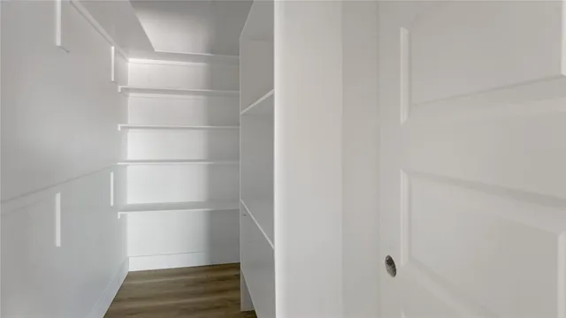 a view of walk in closet with empty racks