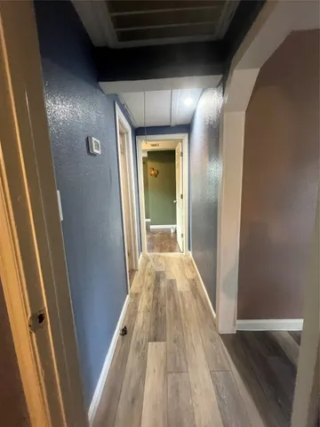 a view of a hallway with wooden floor