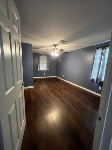 en empty room with wooden floor and window