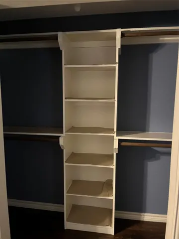 a view of walk in closet with empty racks