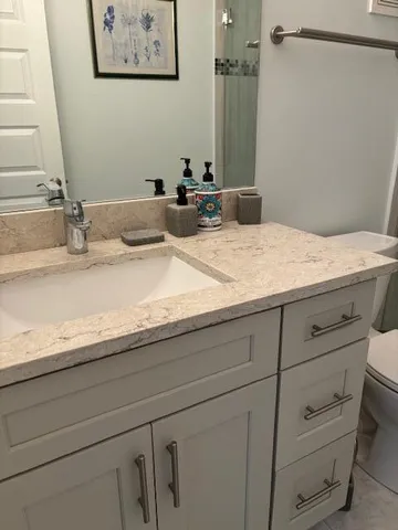 a bathroom with a granite countertop sink and a mirror
