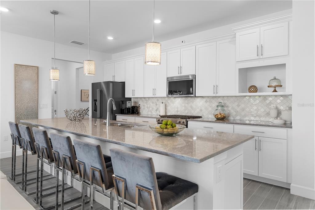 42363 Edgewater Drive Punta Gorda, FL 33982 - Photo 11 of 72 a kitchen with stainless steel appliances granite countertop a table chairs sink refrigerator and cabinets