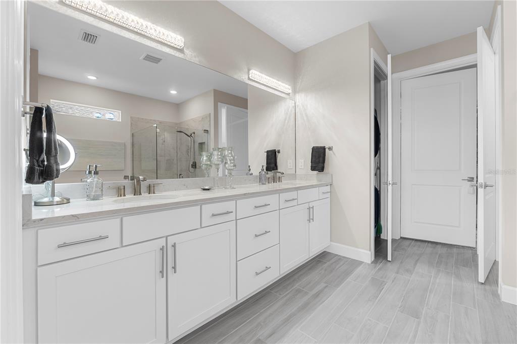 42363 Edgewater Drive Punta Gorda, FL 33982 - Photo 27 of 72 a spacious bathroom with double vanity a mirror and a shower