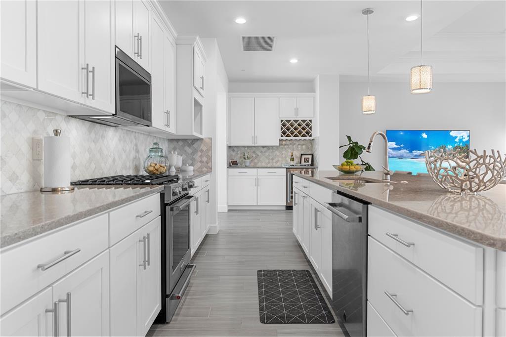 42363 Edgewater Drive Punta Gorda, FL 33982 - Photo 9 of 72 a kitchen with stainless steel appliances kitchen island granite countertop a sink a stove top oven and white cabinets