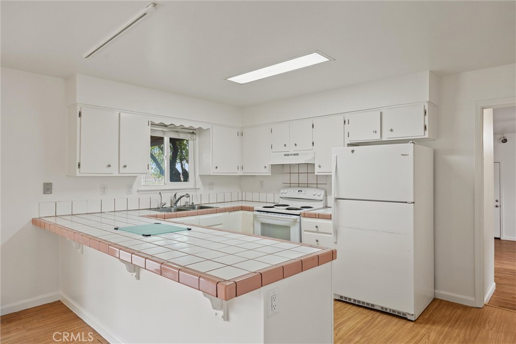 4229 Caballo Way Chico, CA 95973 - Photo 19 of 42 a kitchen with a sink a stove a refrigerator and white cabinets