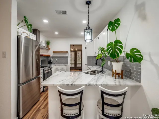 a kitchen with refrigerator and table