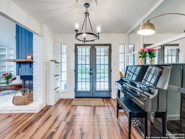 a living room with furniture a fireplace and a chandelier