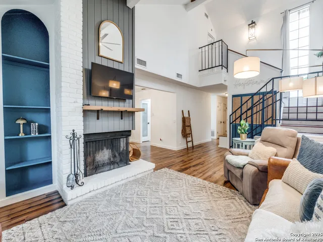 a living room with furniture a flat screen tv and a fireplace