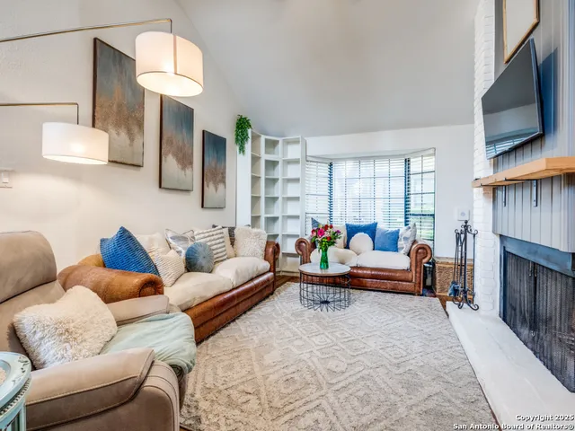 a living room with furniture a fireplace and a flat screen tv