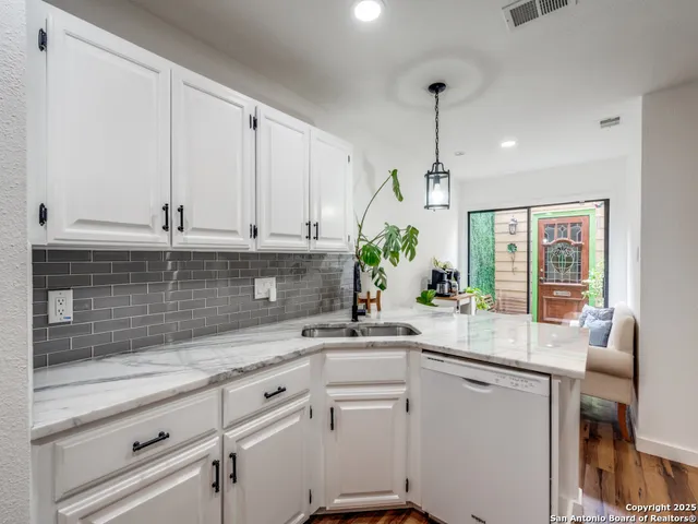 a kitchen with granite countertop white cabinets and white appliances