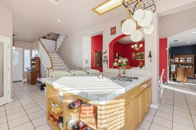 a large kitchen with stainless steel appliances granite countertop a sink and a large mirror