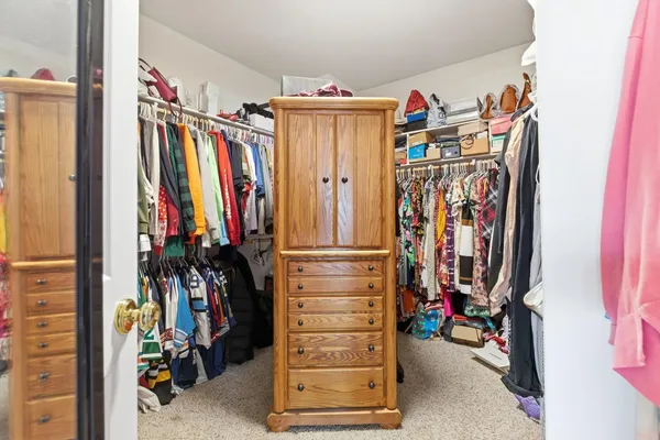 a view of walk in closet with clothes