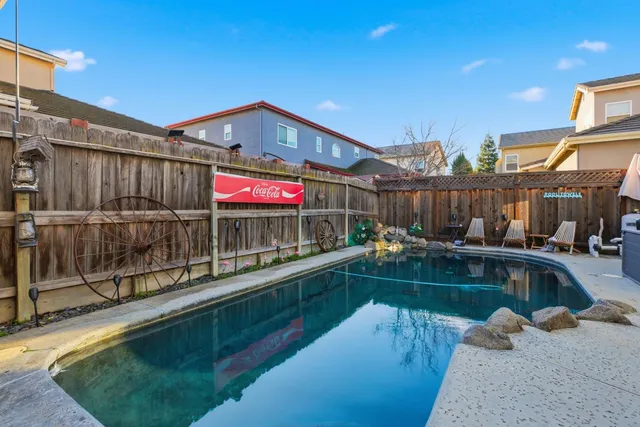 a view of a swimming pool with a patio and a fountain