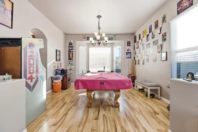 a dining room with wooden floor and chandelier