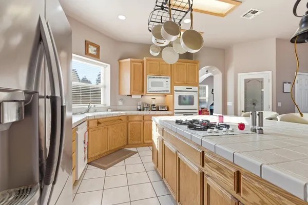 a kitchen with stainless steel appliances granite countertop a sink a stove and a refrigerator