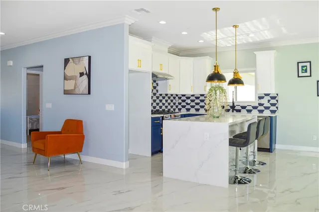 a kitchen with stainless steel appliances kitchen island granite countertop a table and chairs