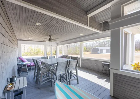a dining room with furniture a floor to ceiling window and wooden floor
