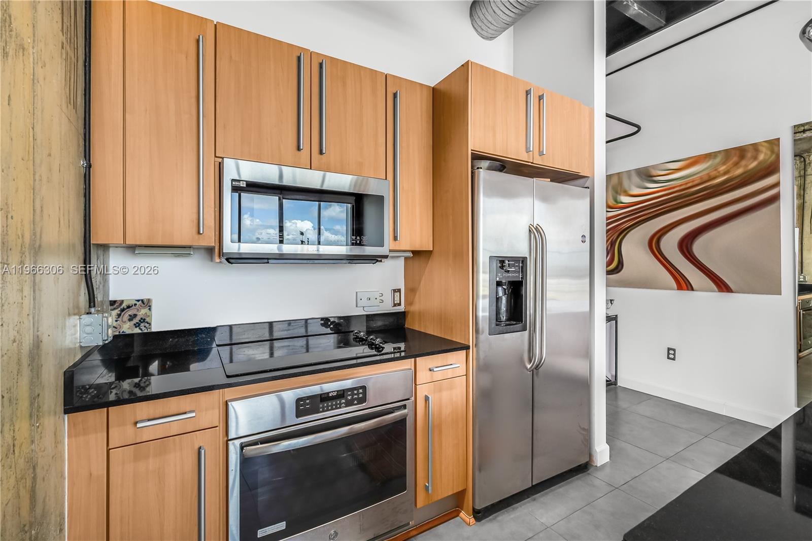 8101 Biscayne Boulevard, Unit R613 Miami, FL 33138 - Photo 9 of 33 a kitchen with stainless steel appliances granite countertop a stove a refrigerator and a microwave