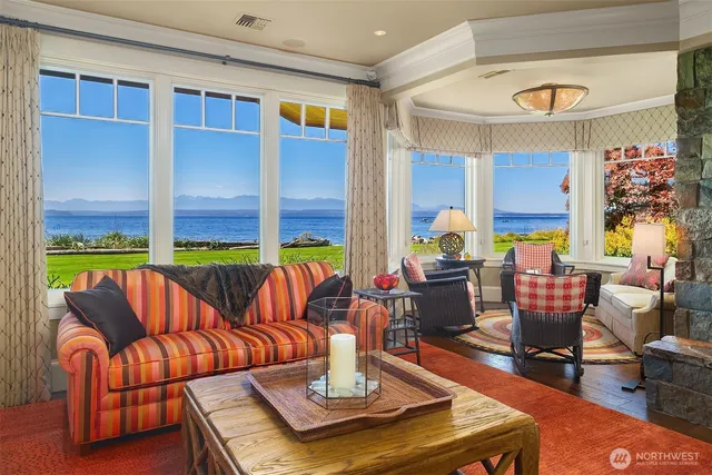 a living room with furniture kitchen view and a large window
