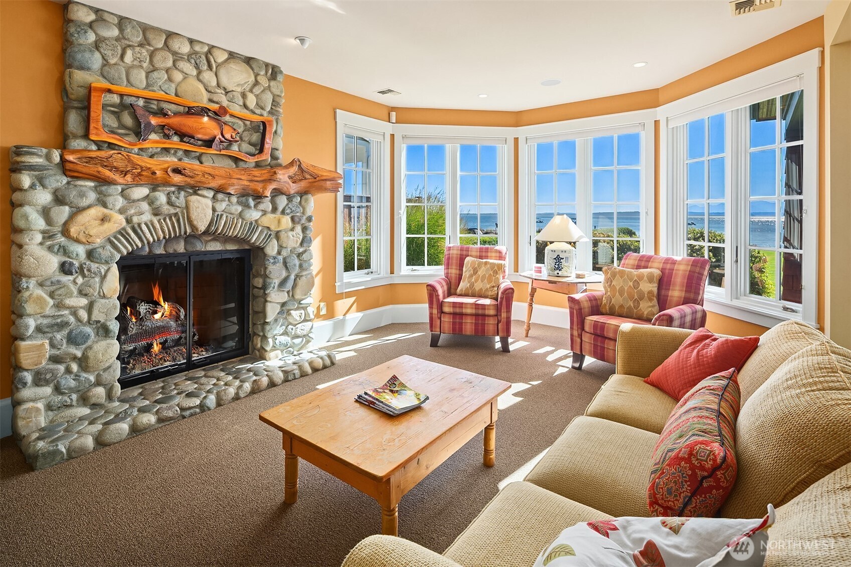 5844 Mutiny Bay Road Freeland, WA 98249 - Photo 30 of 35 a living room with furniture a fireplace and a floor to ceiling window