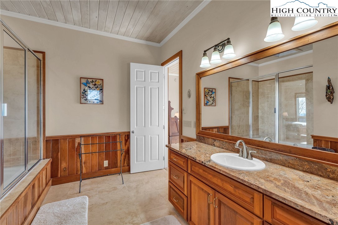 933 Thunder Ridge Lane Lenoir, NC 28645 - Photo 27 of 45 a spacious bathroom with a granite countertop sink and a large mirror