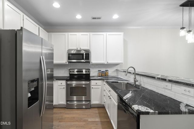 a kitchen that has a sink and a stove in it