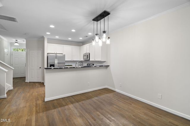 a view of a kitchen with furniture and wooden floor