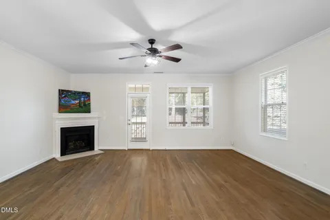 a view of a kitchen with a stove a kitchen island wooden floor and a ceiling fan