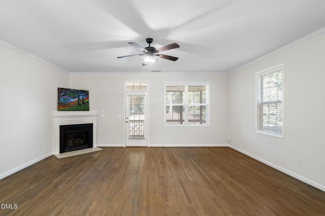 a view of a kitchen with a stove a kitchen island wooden floor and a ceiling fan