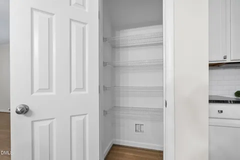 a view of hallway with wooden floor and chandelier