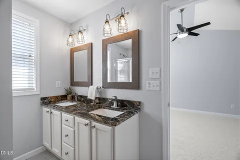 a bathroom with a granite countertop sink a toilet and a mirror