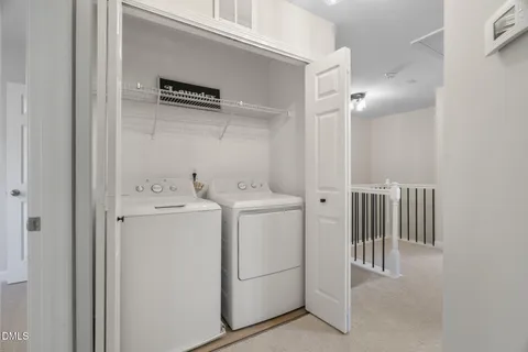 a view of a white house with a large window and yard