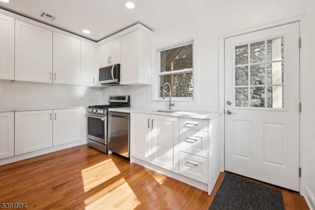 a kitchen with stainless steel appliances granite countertop a stove and a sink