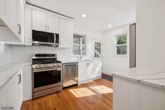 a kitchen with stainless steel appliances a stove microwave and sink