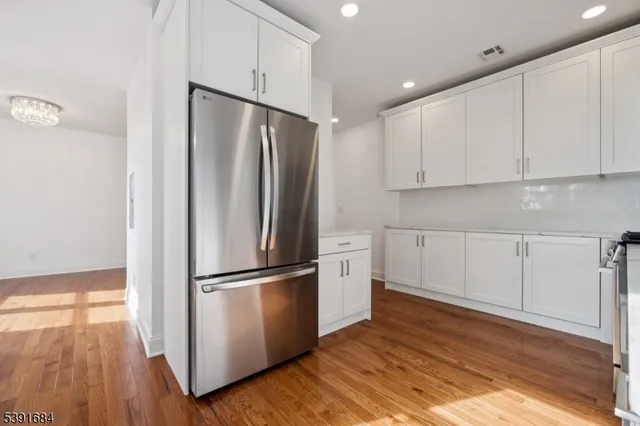 a kitchen with granite countertop white cabinets and stainless steel appliances