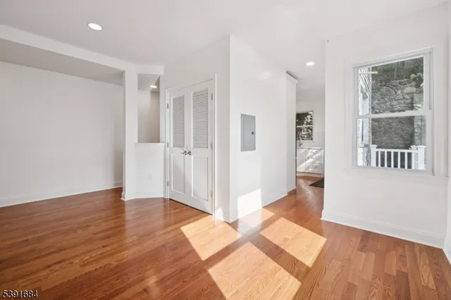 a view of a hallway with wooden floor and a living room