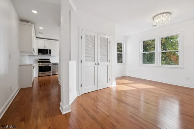 a view of a kitchen with wooden floor and a window