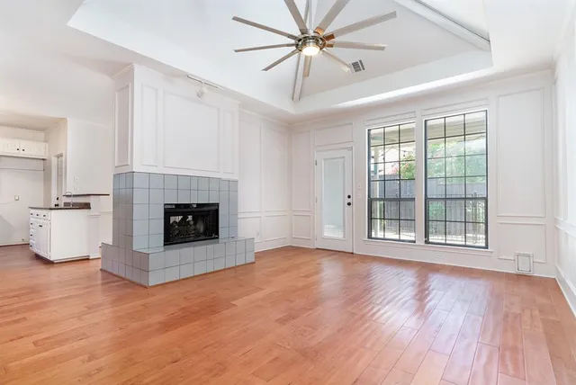 a view of empty room with a fireplace and wooden floor
