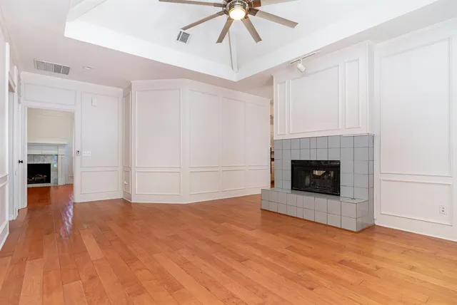 a view of empty room with wooden floor and fireplace