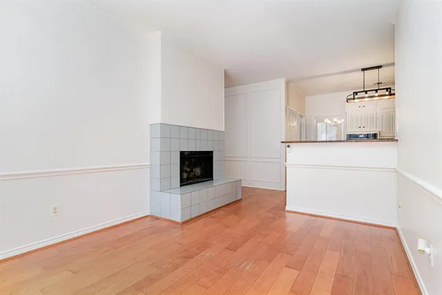 a view of a livingroom with wooden floor and a fireplace