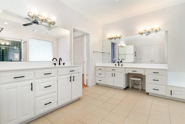 a spacious bathroom with a double vanity sink a mirror a vanity and a bathtub