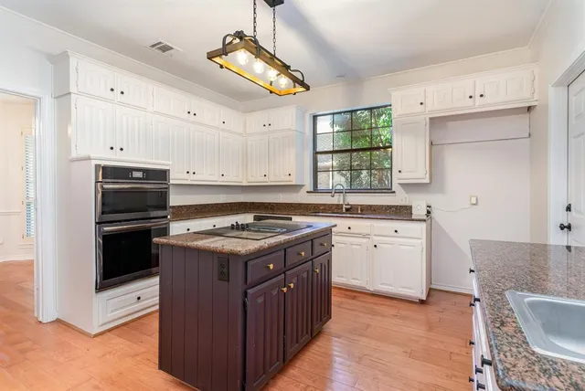 a kitchen with a stove cabinets and wooden floor