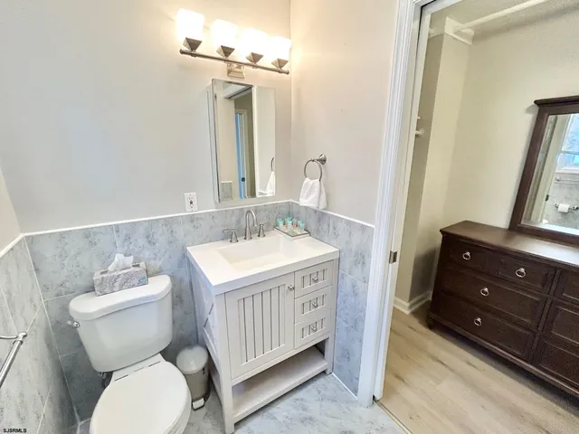 a bathroom with a granite countertop toilet sink and mirror