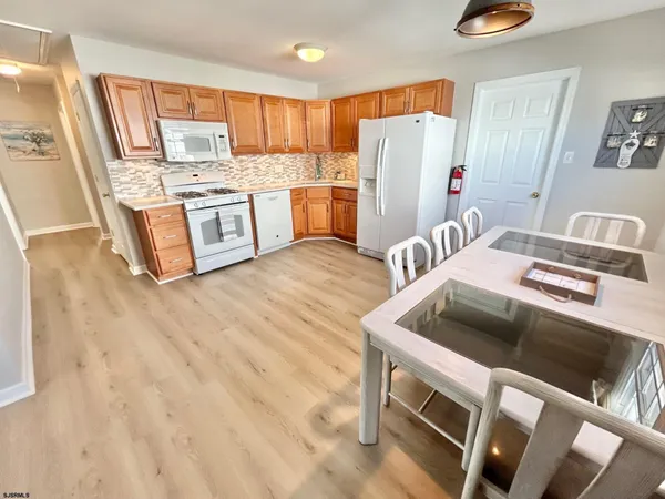 a kitchen with stainless steel appliances granite countertop a refrigerator a stove and a sink with wooden floor