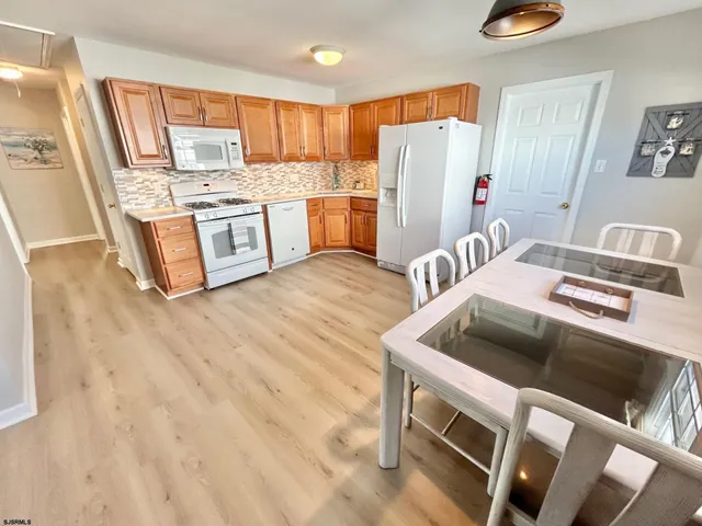 a kitchen with stainless steel appliances granite countertop a refrigerator a stove and a sink with wooden floor