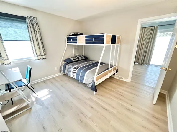 a bedroom with a bed and wooden floor