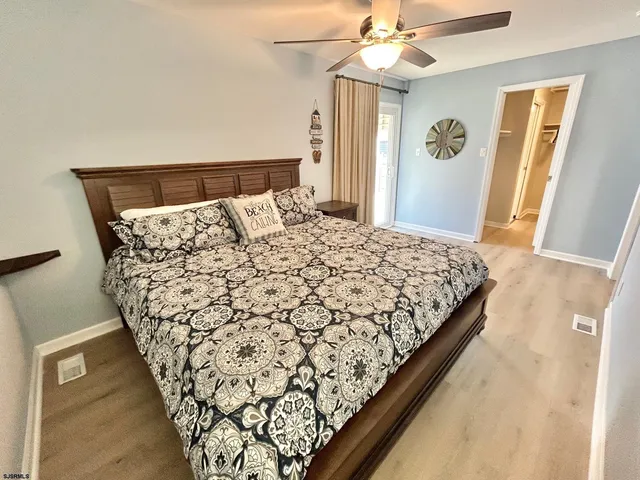 a large bed sitting in a bedroom next to a window and a chandelier