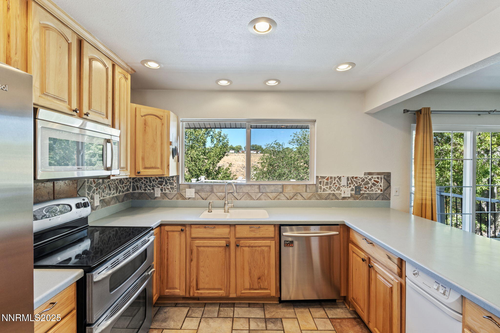 2275 Solari Drive Reno, NV 89509 - Photo 13 of 52 a kitchen with stainless steel appliances granite countertop a stove a sink and a microwave