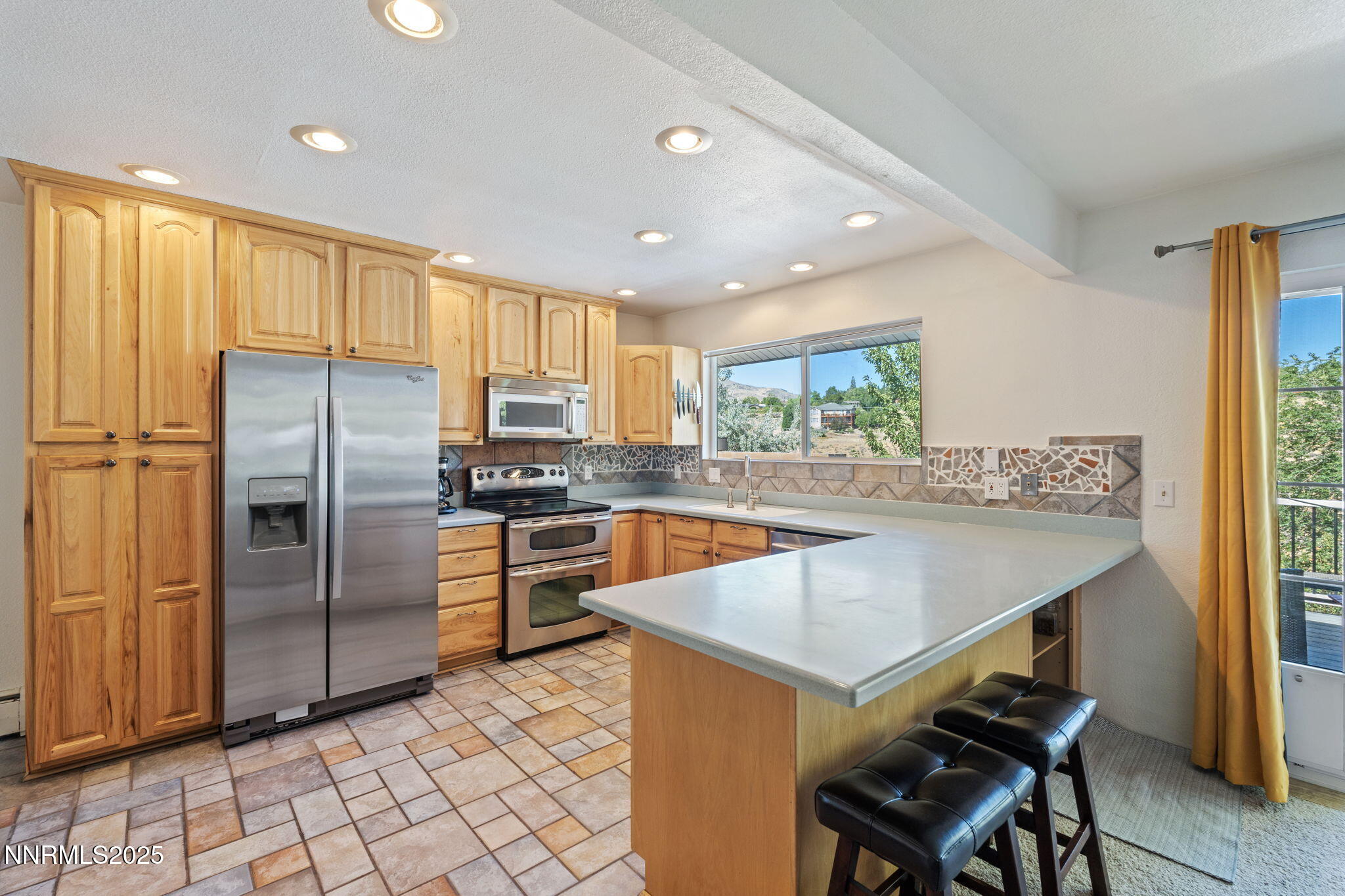 2275 Solari Drive Reno, NV 89509 - Photo 15 of 52 a kitchen with stainless steel appliances granite countertop a refrigerator a sink a stove a dining table and chairs